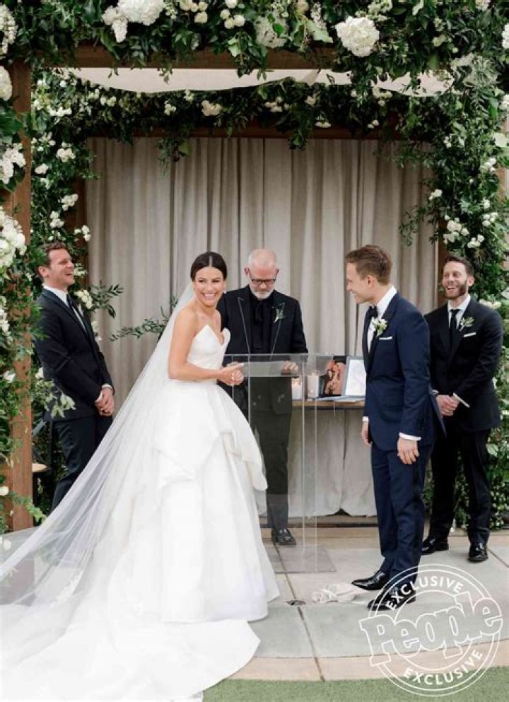 Both Lea Michele and Zandy Reich are smiling looking at each other.
