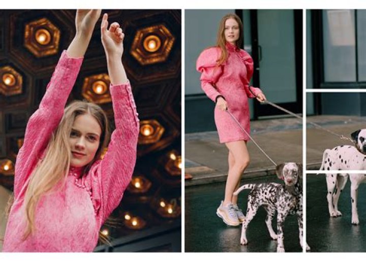 Hera Hilmar in a pink one piece with her black spotted white dogs.