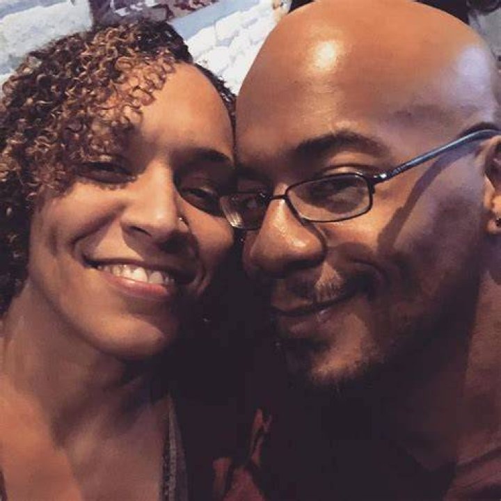 Taina Smits posing with her husband by wearing black outfit.